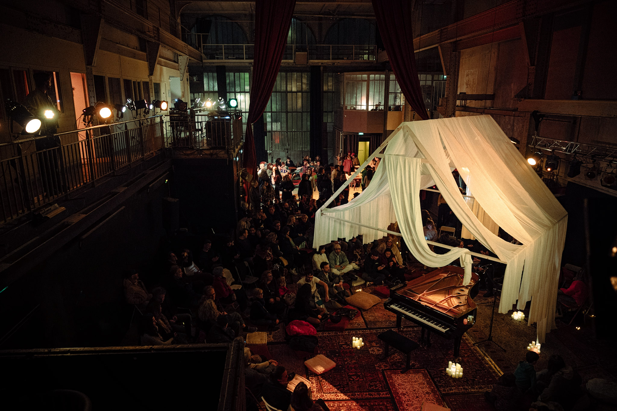 Public assis autour du piano lors d'un concert au Consulat